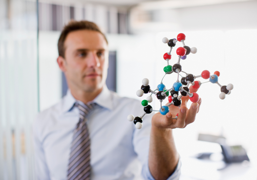 Businessman examines a free radical molecule representation