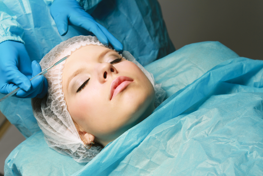 Woman getting a cosmetic surgery done on her face. 