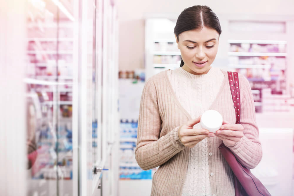 Woman reading cosmetic label 