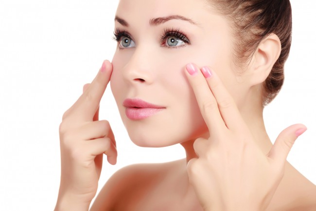 Young woman applying anti-aging products.