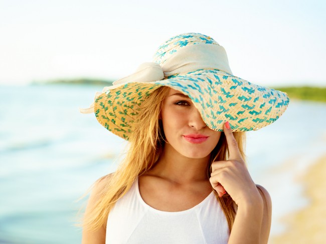 Beautiful woman wearing a hat in a beach