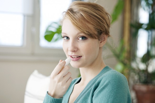 Woman applying lip balm