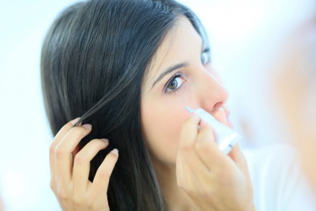 Woman applying concealer.