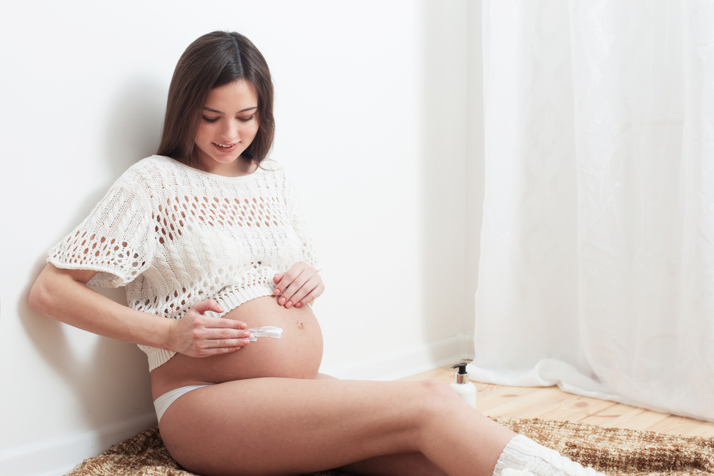 Woman applying cream to prevent stretch marks