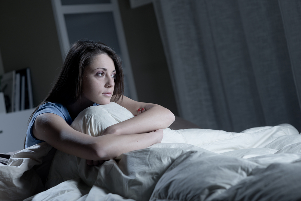 Woman sitting on her bed