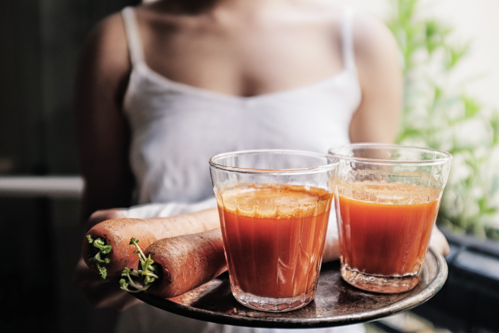 Woman drinking carrot juice 