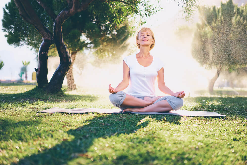 Mature woman doing yoga in the park