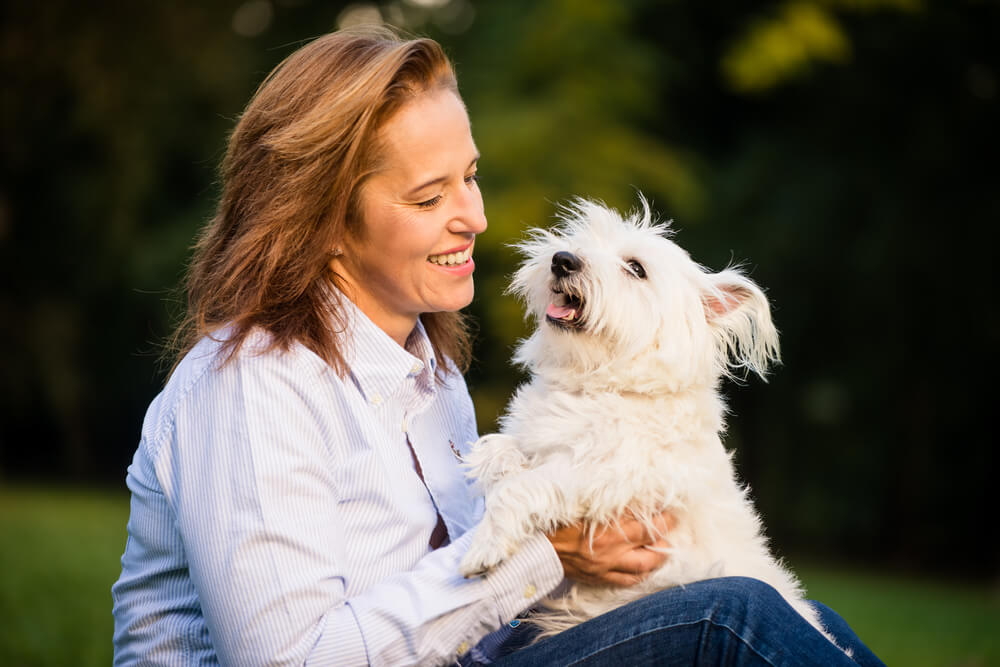 Happy woman with happy white fluffy dog