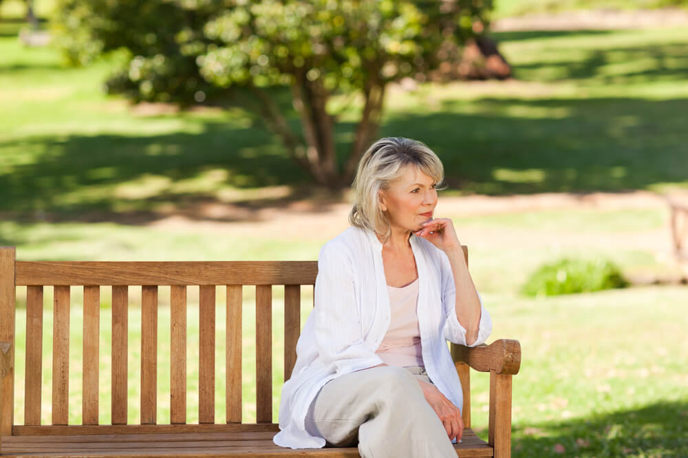 senior woman sitting on park bench