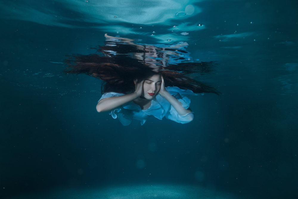 Woman in water closing her ears