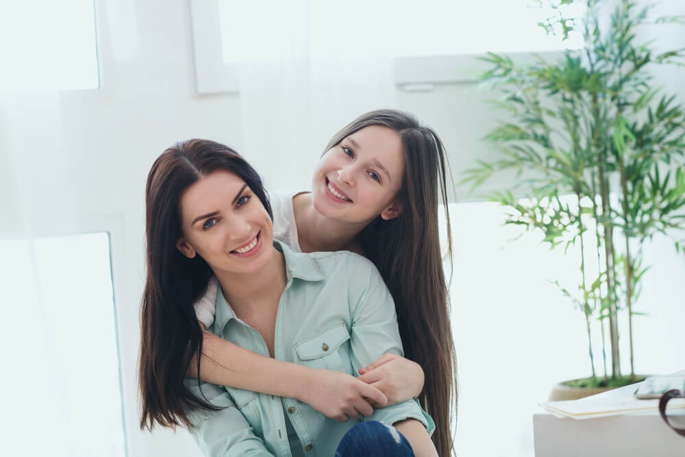 Teenage daughter hugging her mother