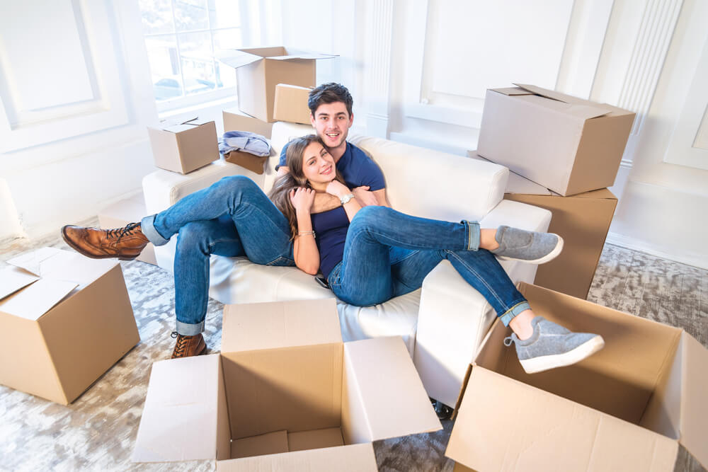 Couple moving in together with boxes all around