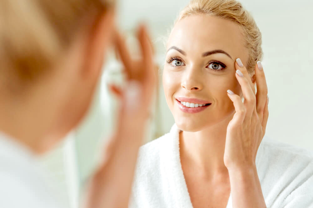 woman touching the skin around her eyes