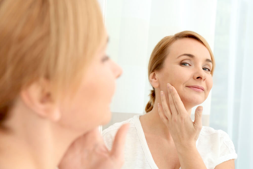 woman touching neck in the mirror