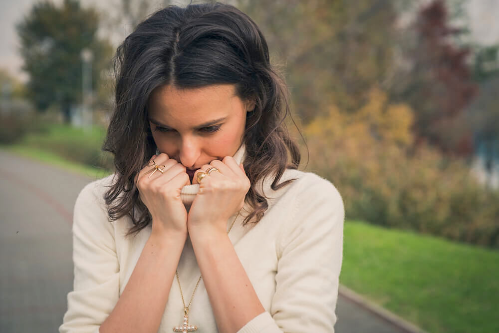 Woman covering her face with her sweater 