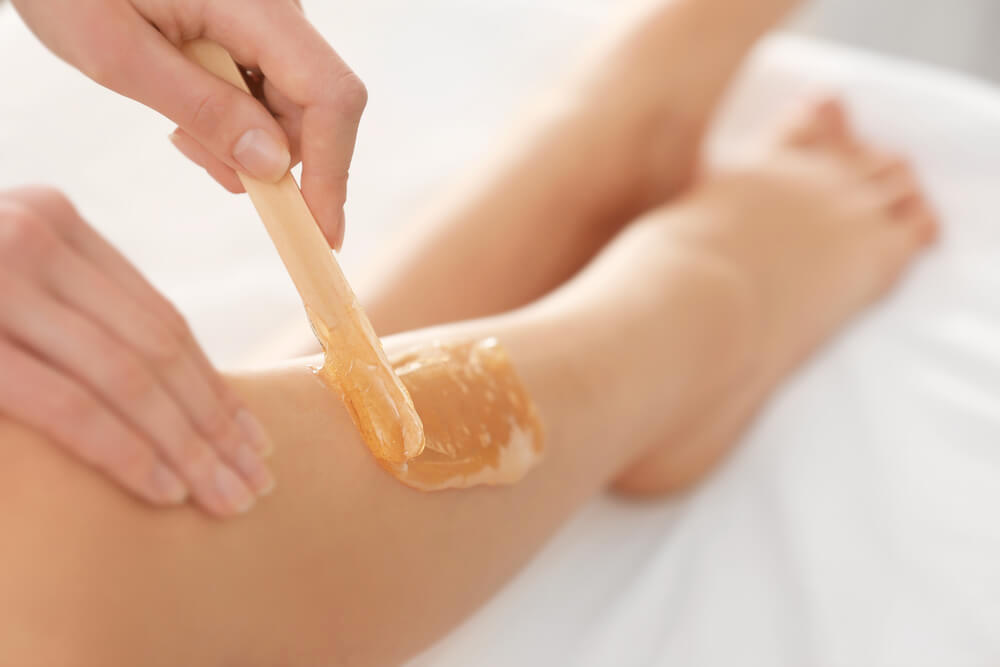 Unknown woman waxing legs at home